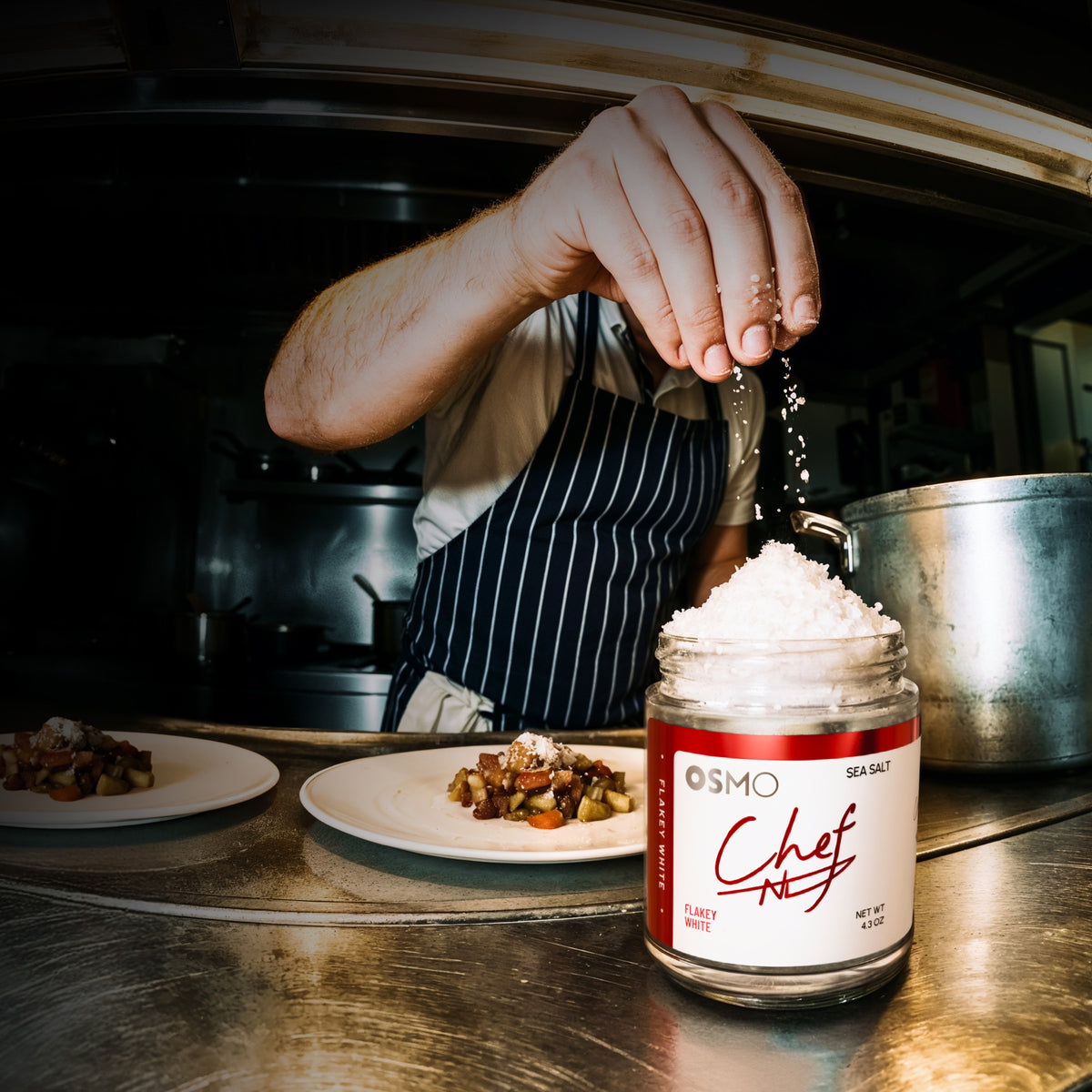 A chef finishing plates with Flakey White Sea Salt