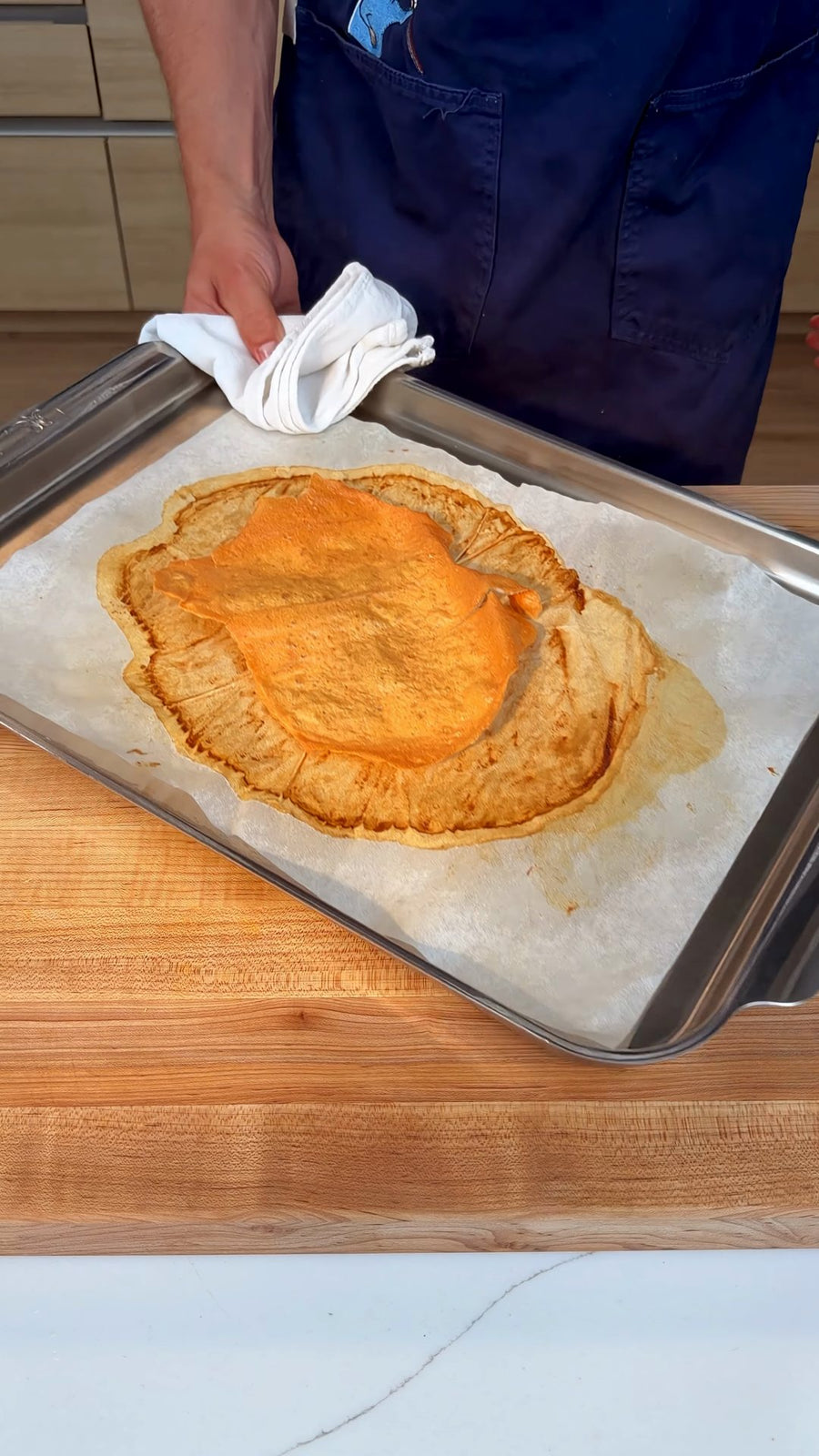 Nick holds the tray of baked, golden chicken chip after removing it from the oven.