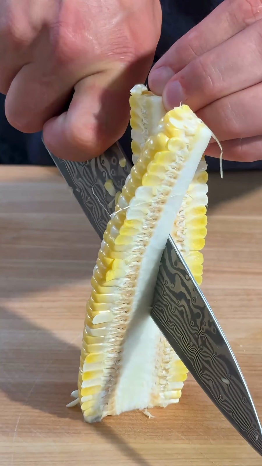Nick cuts the corn into long quarters with the cob attached.