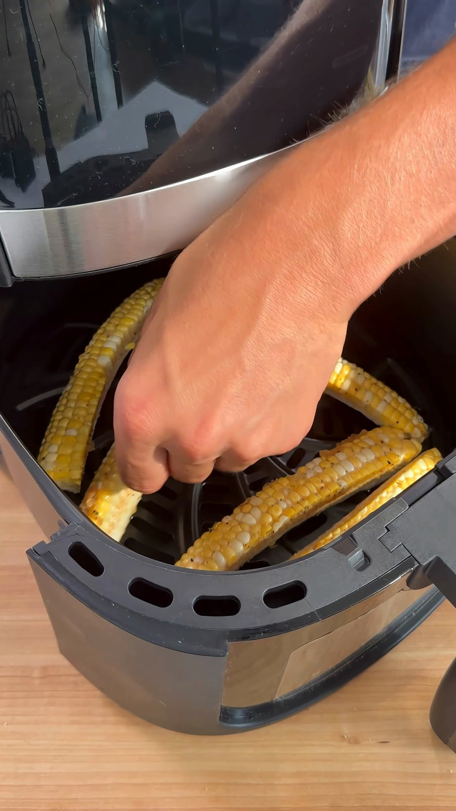 Nick arranges seasoned corn ribs in a single layer in the air fryer basket.
