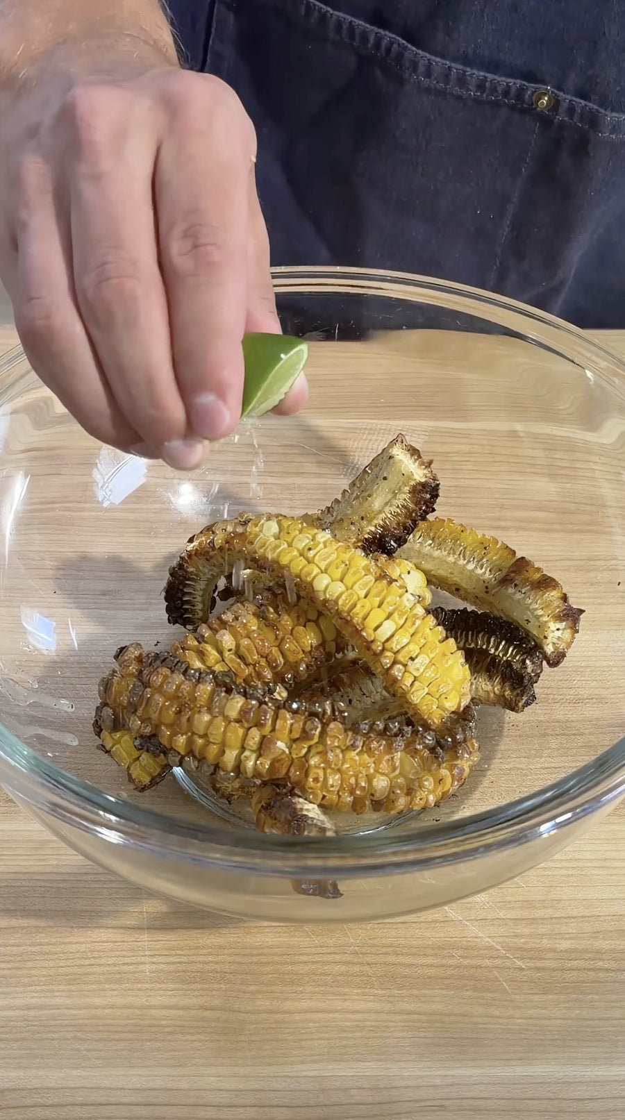 Nick pours melted butter over the cooked corn ribs.