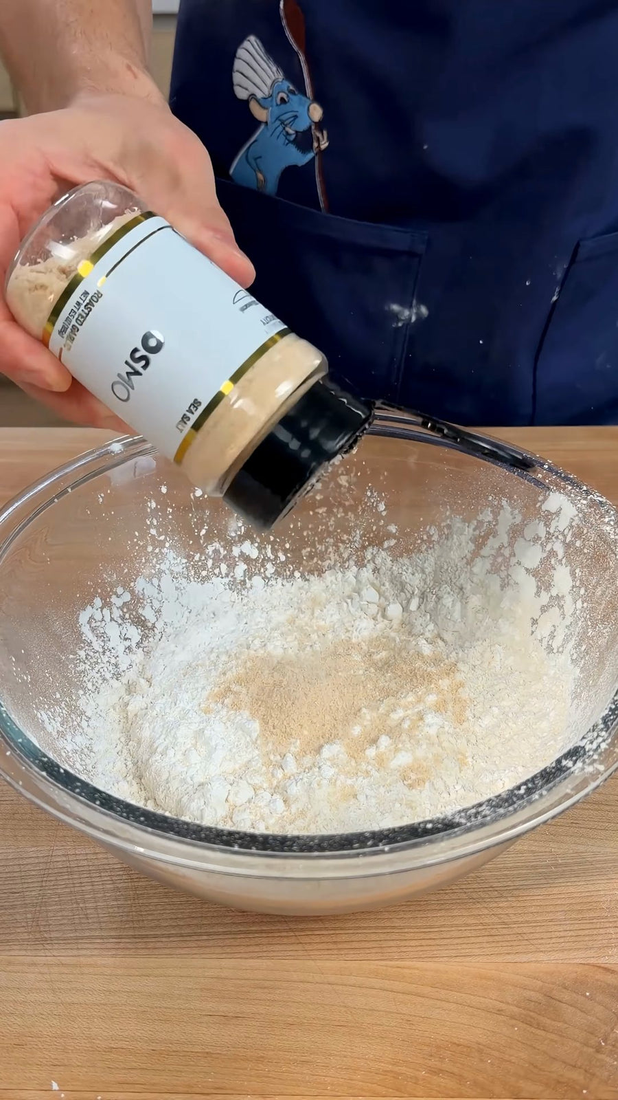 Nick shakes Osmo Roasted Garlic Sea Salt from its clearly visible jar into the dry ingredients.