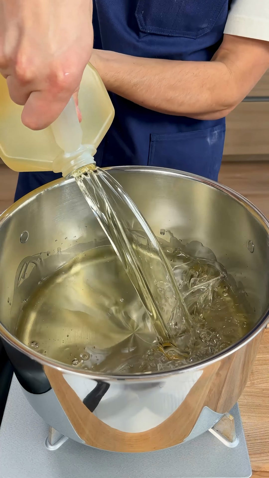 Nick pours frying oil into a deep pot before heating it.