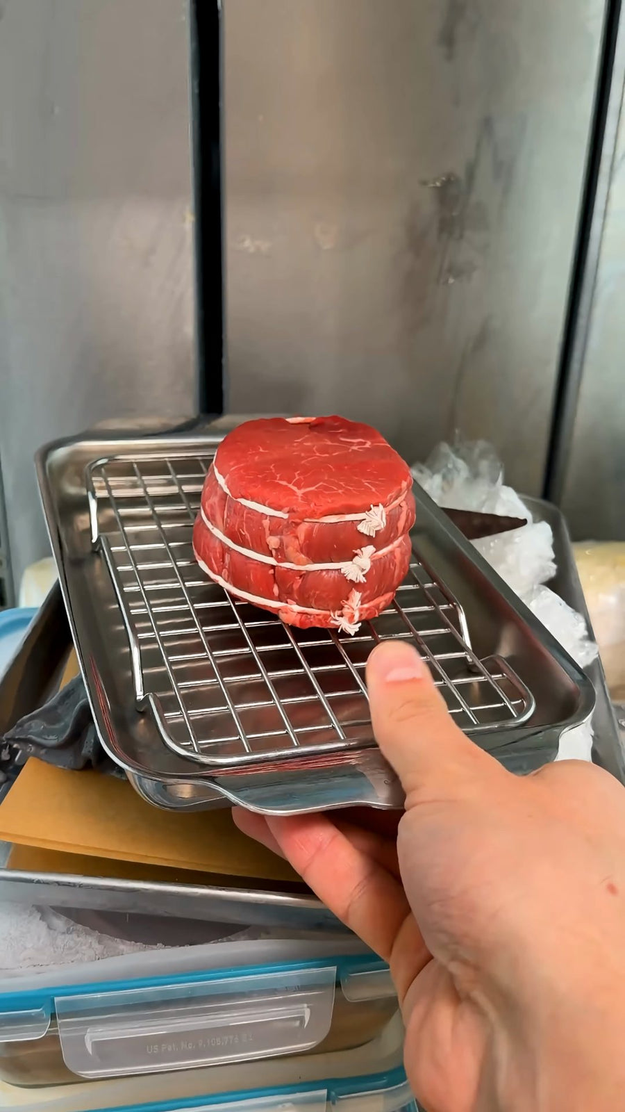 Nick places beef tenderloin in the freezer to firm it for slicing.