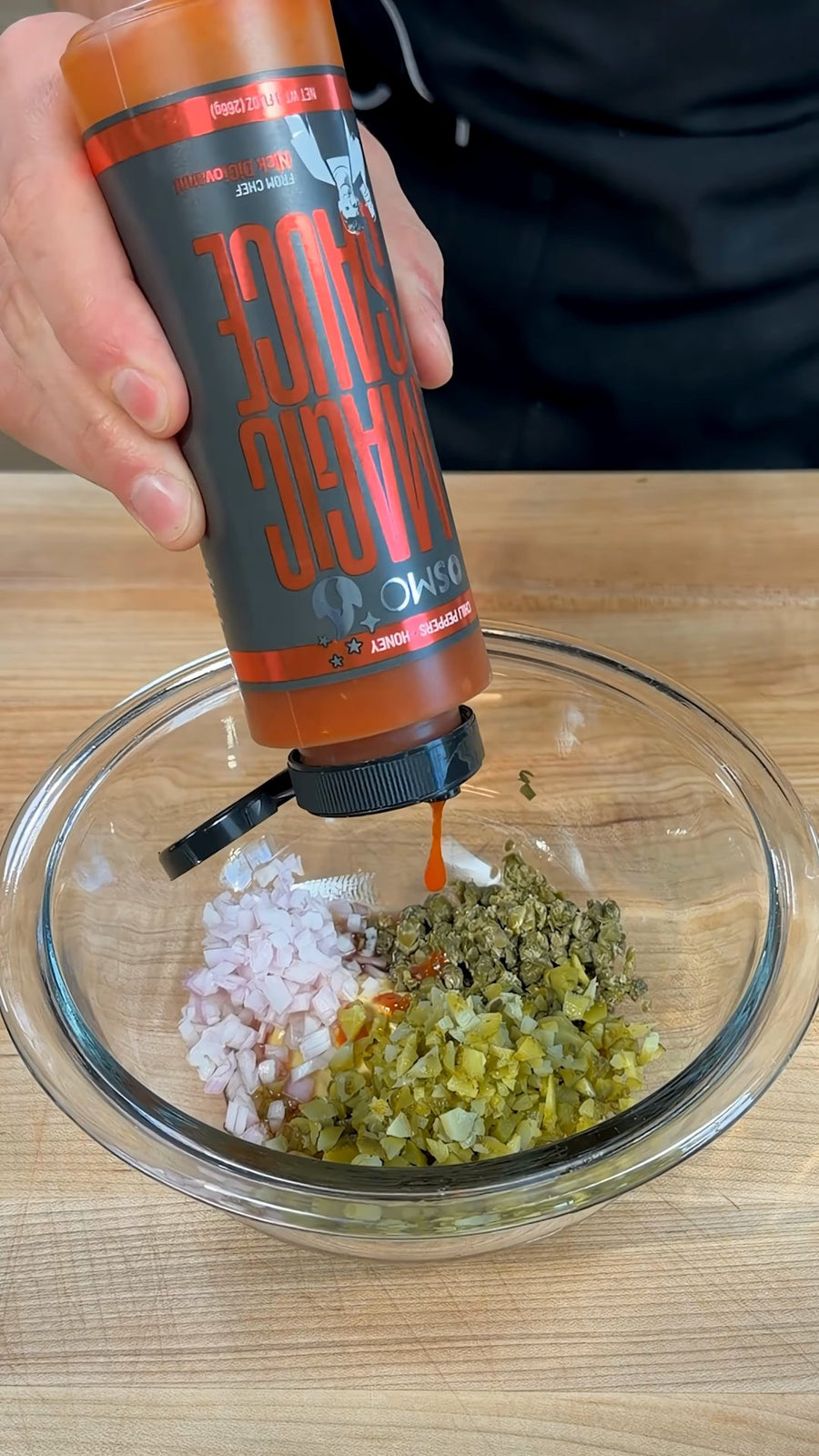 Nick holds Osmo Magic Sauce over the tartare dressing bowl.